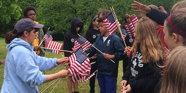 Students from Academie Lafayette have clean up and placed flags at neglected African American Highland Cemetery.